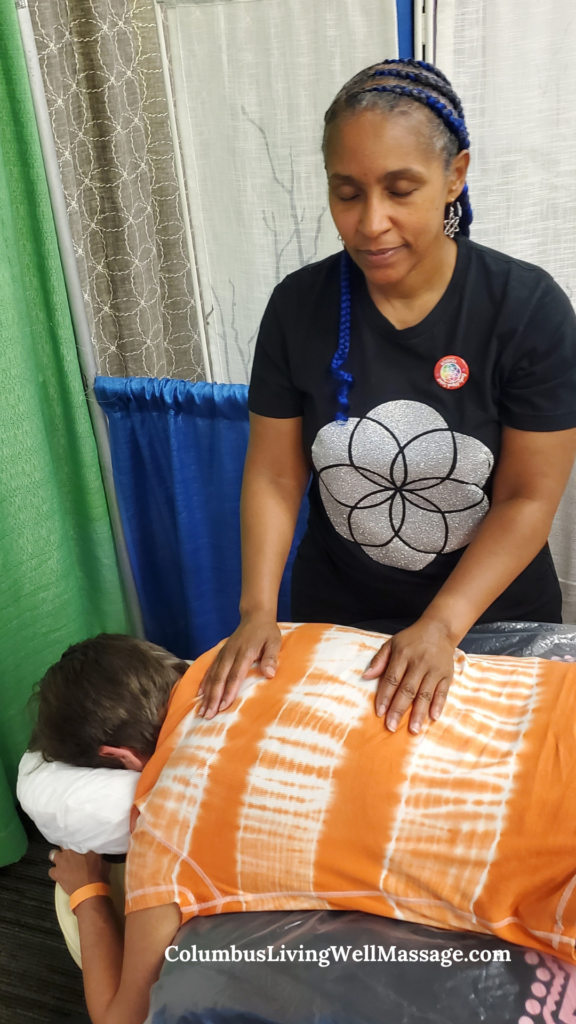 Massage therapist providing Reiki and energy wellness session in a peaceful healing environment